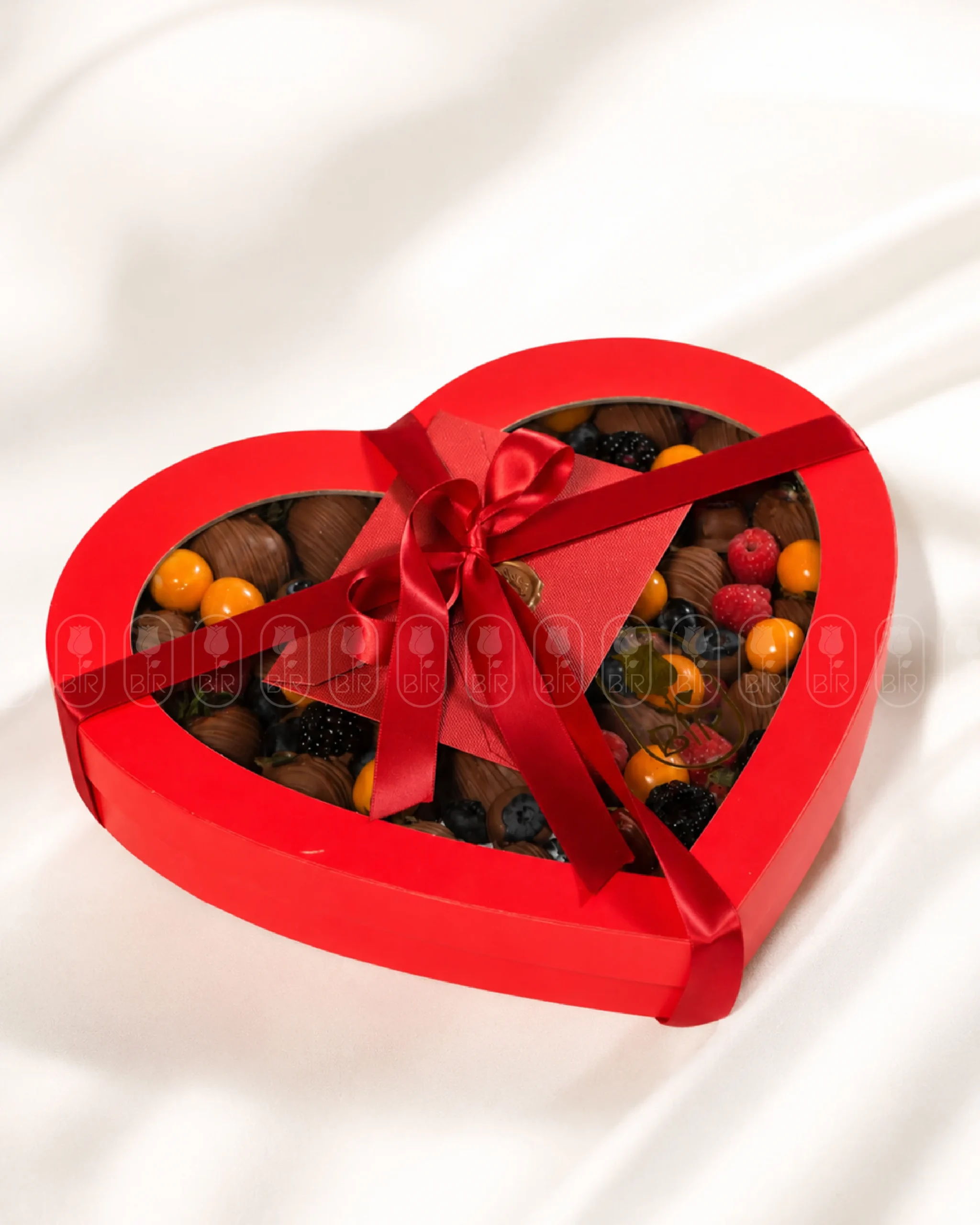 Red heart-shaped box filled with Belgian chocolate-covered strawberries and fresh berries