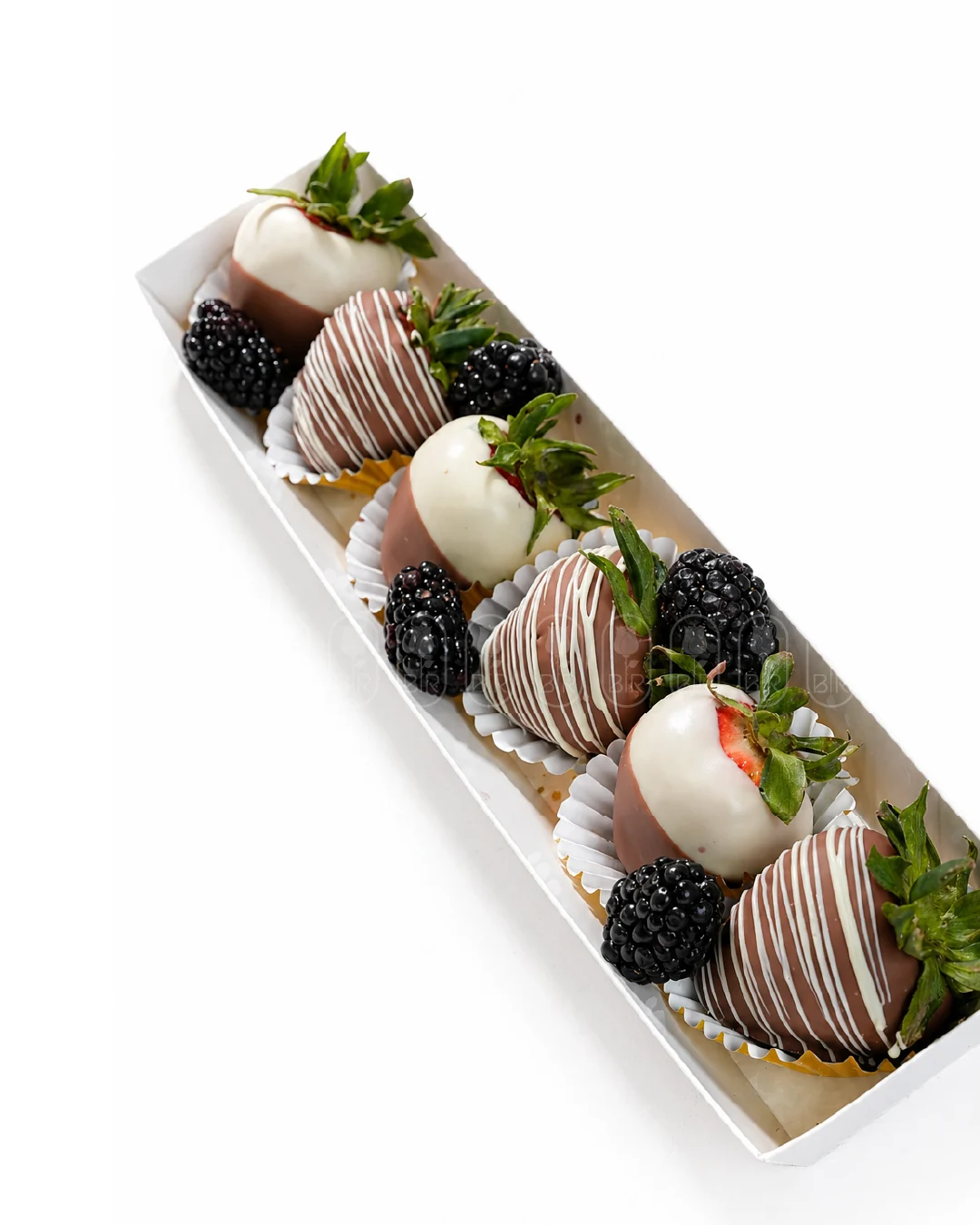 Luxury chocolate-dipped strawberries with blackberries in an elegant gift box