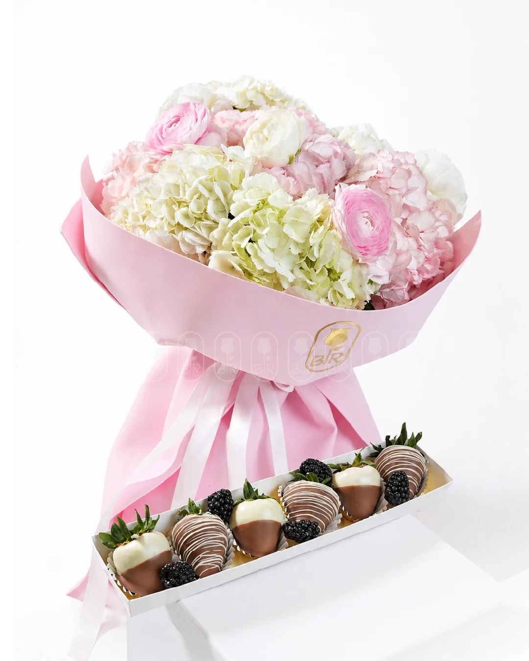 Luxury pastel flower bouquet with hydrangeas and pink blooms paired with chocolate-dipped strawberries and blackberries