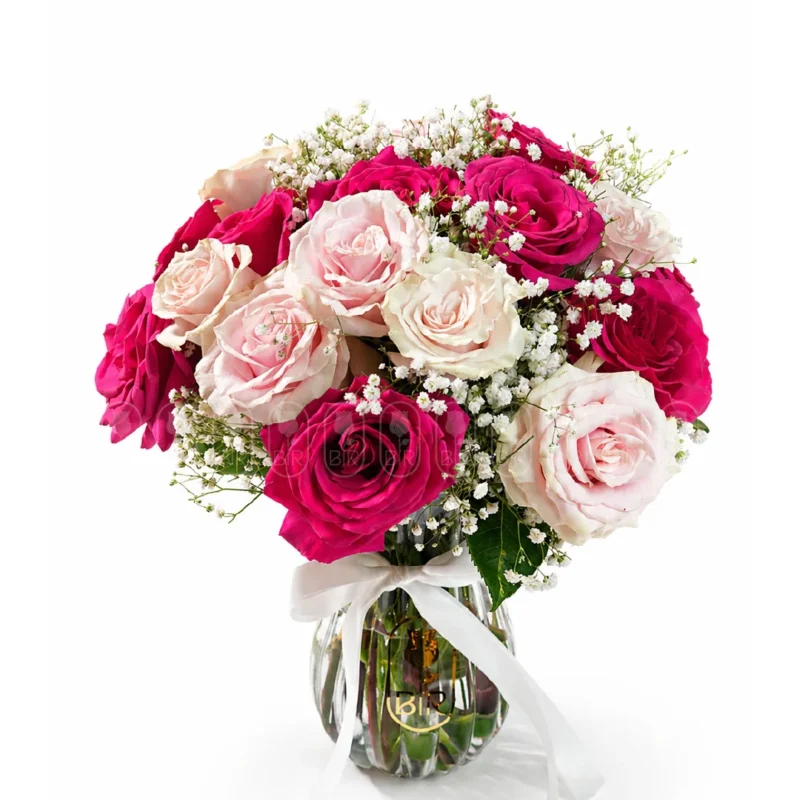 Pink and white rose bouquet with baby’s breath in a glass vase