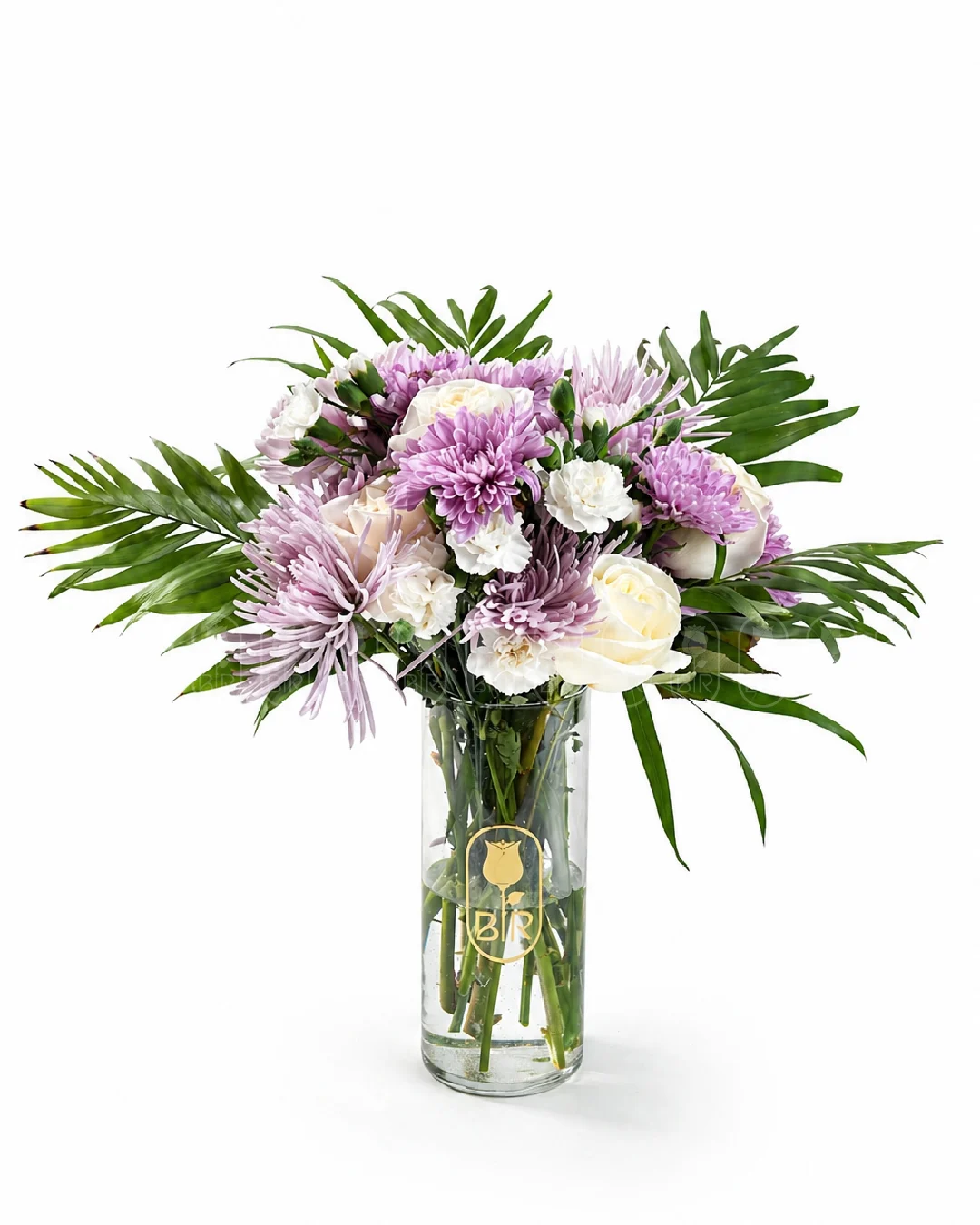 Soft purple and white floral arrangement in a clear glass vase with greenery