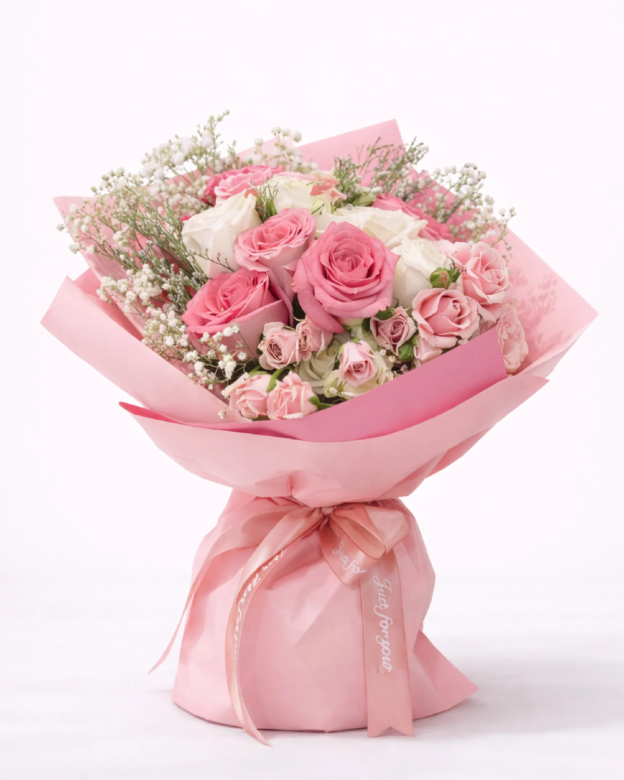 Soft pink and white rose bouquet with baby’s breath wrapped in pink paper