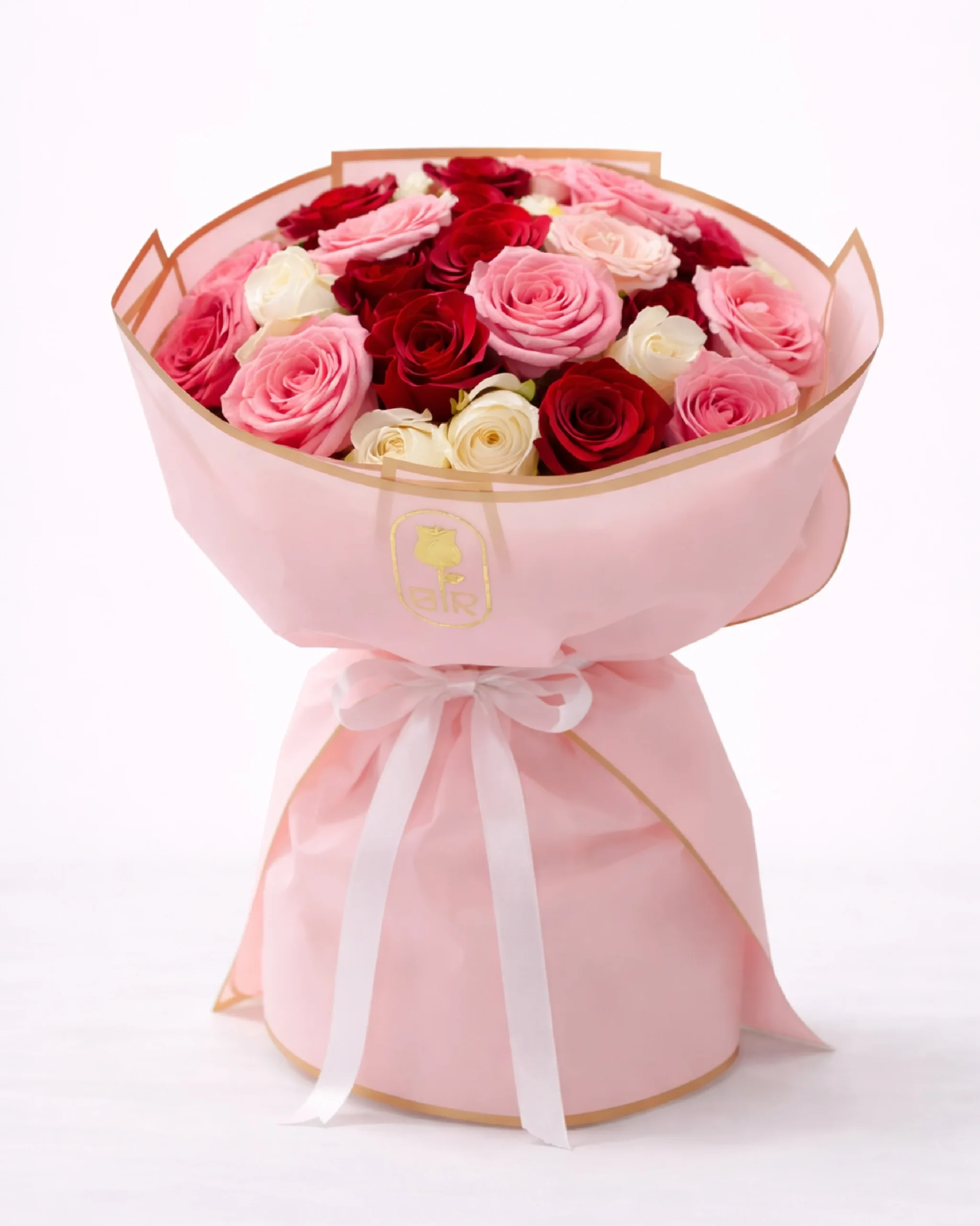 Elegant bouquet of pink, red, and white roses wrapped in blush pink paper