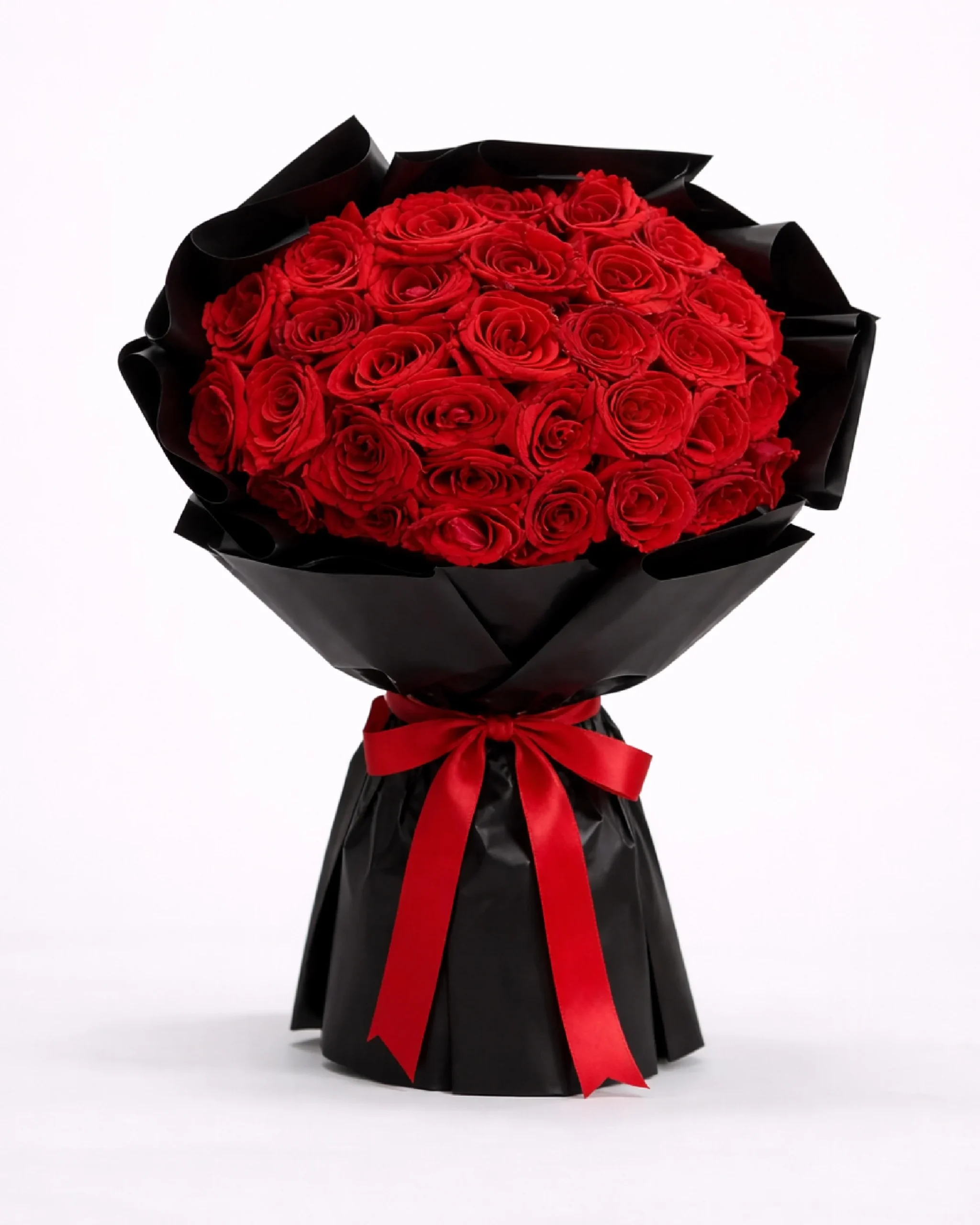 Round bouquet of red roses in black wrap with red ribbon