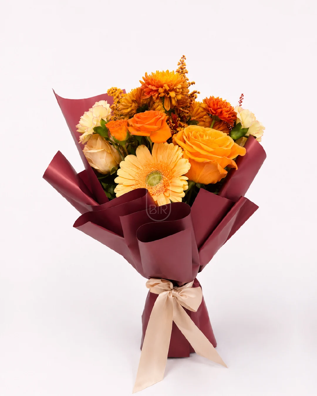 Warm autumn floral bouquet with orange roses and gerbera wrapped in burgundy paper