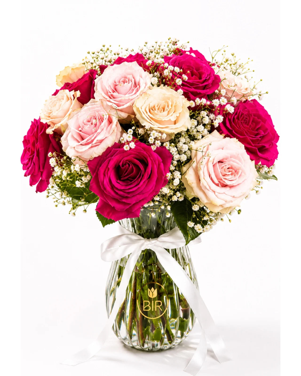 Elegant pink and blush rose bouquet in a glass vase with baby’s breath accents