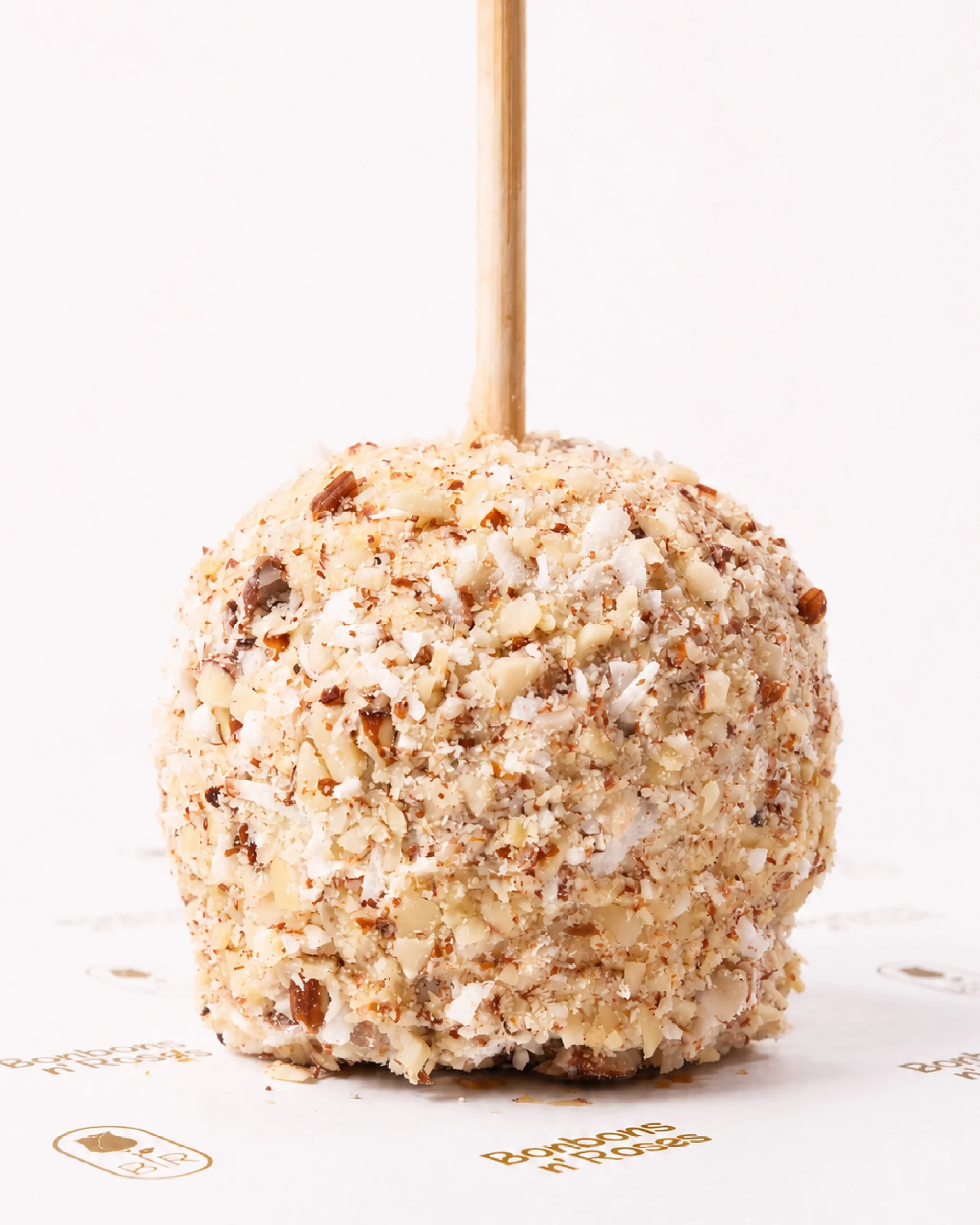 Handcrafted gourmet caramel apple coated with shredded coconut, chopped almonds, and premium white chocolate.