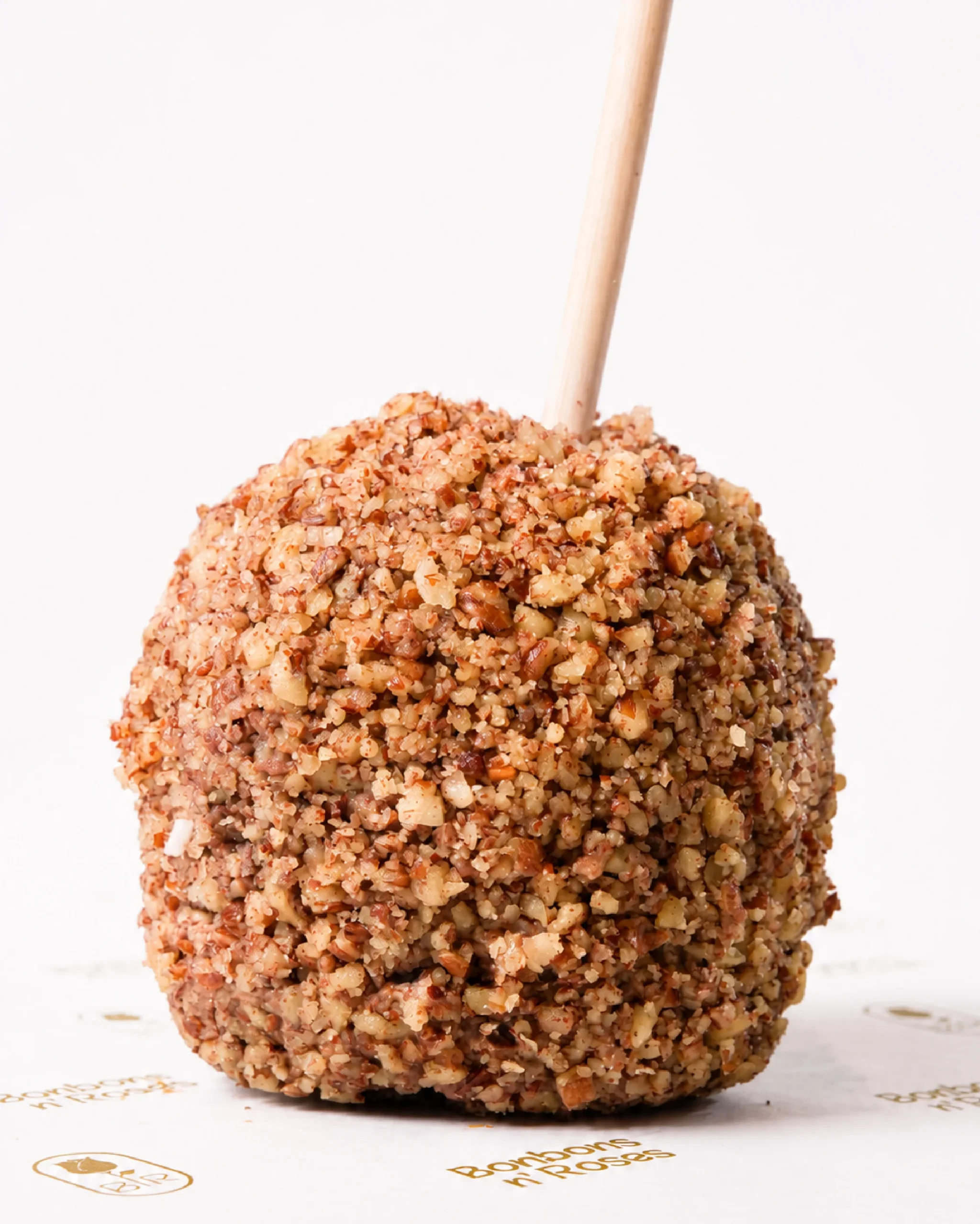 Handcrafted gourmet caramel apple coated with crunchy chopped pecans over premium milk chocolate.