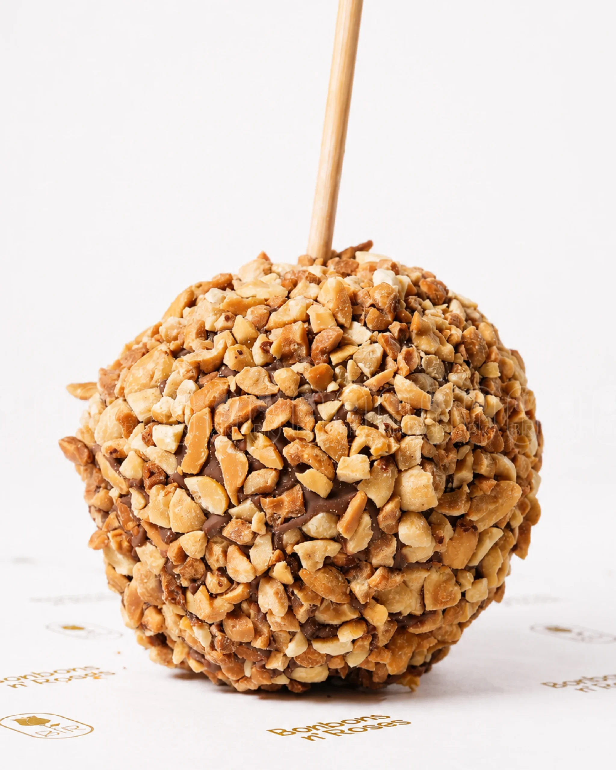 Handcrafted gourmet caramel apple coated with crunchy roasted peanuts over premium milk chocolate.