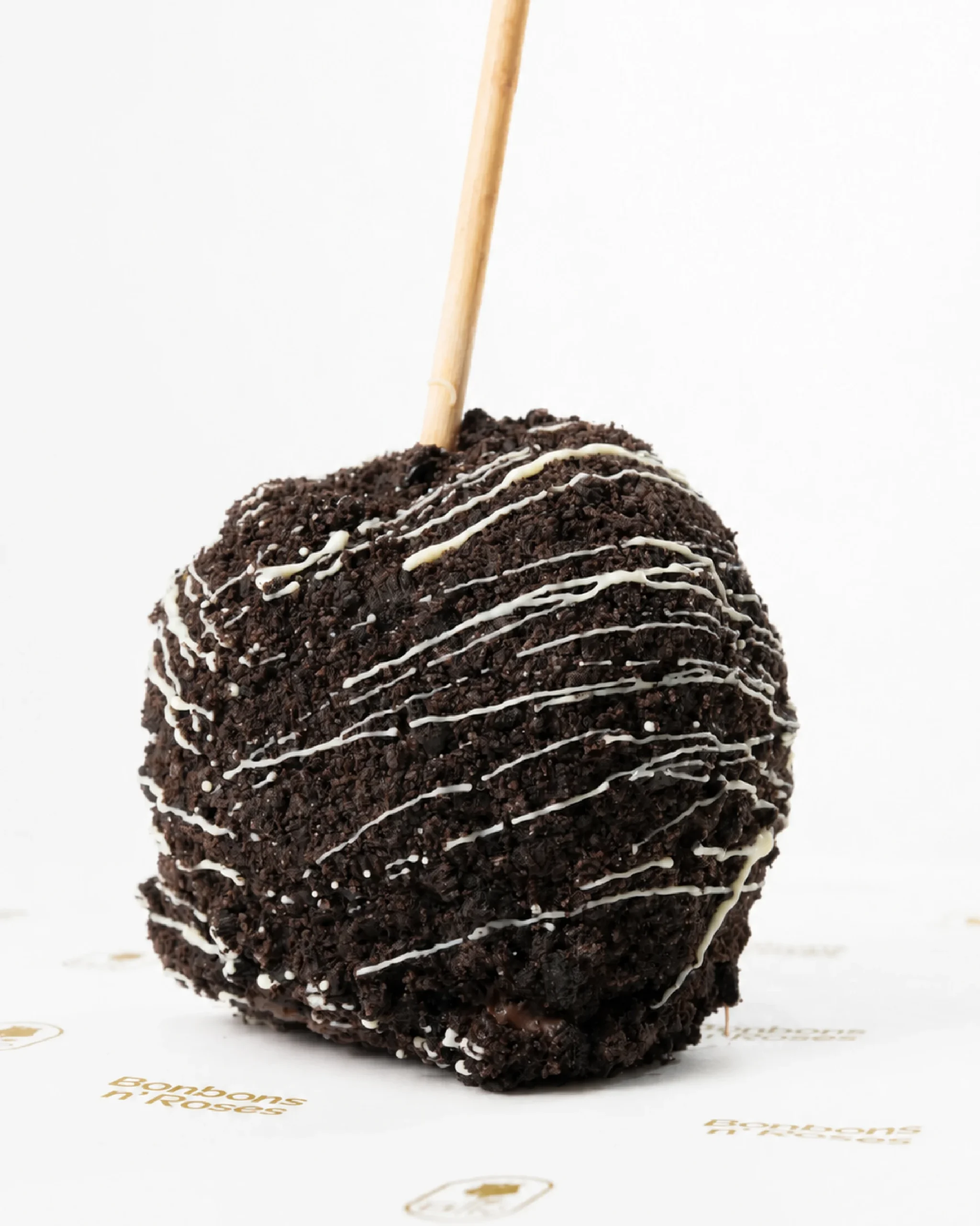 Handcrafted gourmet caramel apple coated with chocolate cookie crumbs and finished with a delicate white chocolate drizzle.